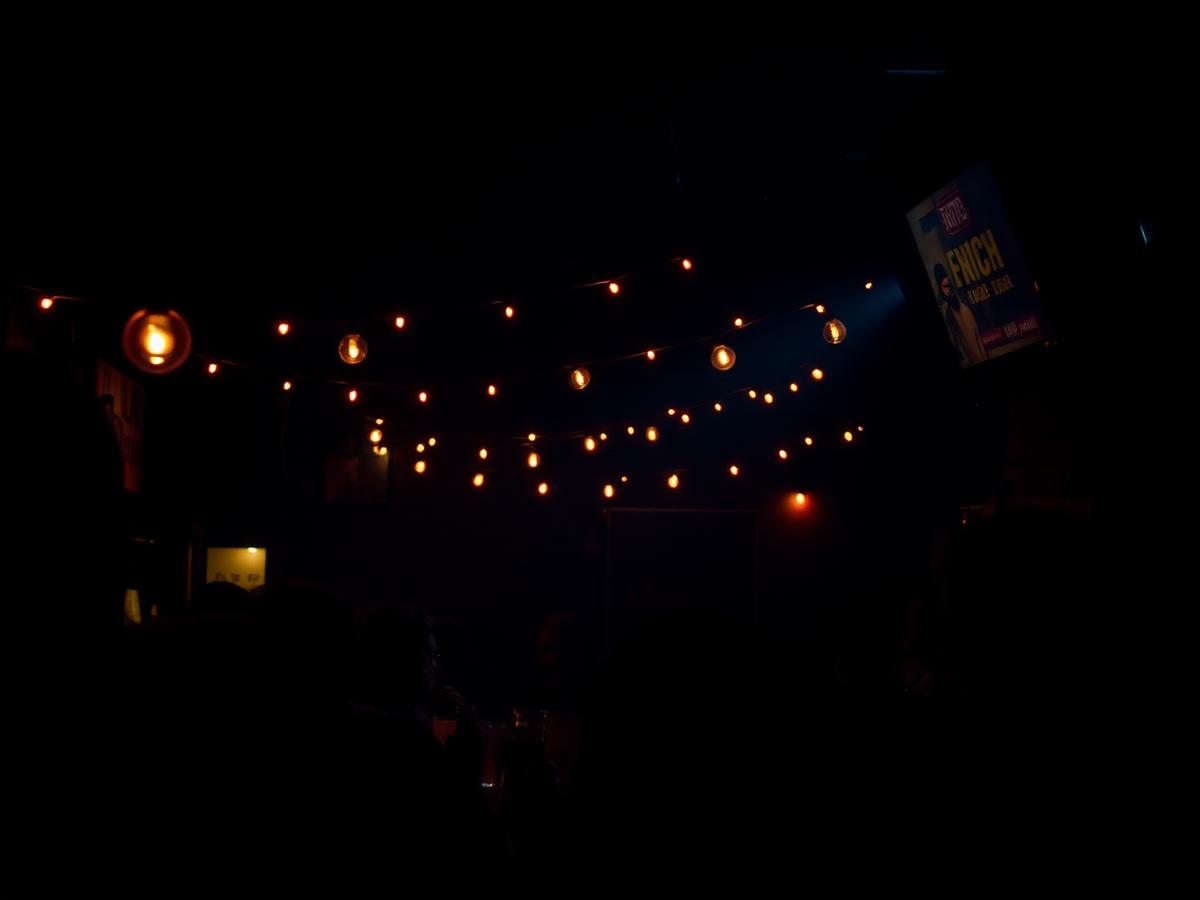 Warm string lights over a packed bar crowd